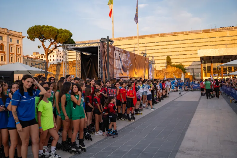 Squadre di pattinaggio schierate lungo l’area dell’evento
